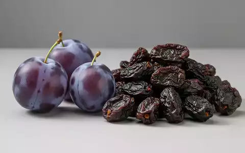 Frische lila Pflaumen und getrocknete braune Pflaumen liegen nebeneinander, um den Unterschied zu zeigen. - Foto: über boerse-global.de