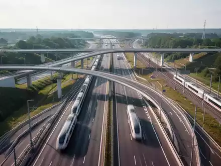 Eine moderne Autobahnbrücke und Schienenwege in einer grünen Landschaft, symbolisiert Infrastrukturfortschritt und schnellere Genehmigungen. - Foto: über boerse-global.de