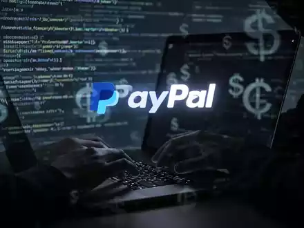 Hands typing on a laptop, with a PayPal logo on the screen, surrounded by digital code reflecting cybercrime. - Foto: über boerse-global.de