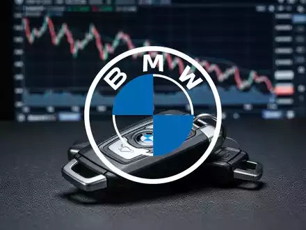 Ein BMW-Autoschlüssel liegt auf einer Oberfläche, im Hintergrund eine unscharfe, fallende Börsenkurve. - Foto: über boerse-global.de