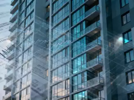 Eine Nahaufnahme der Fassade eines modernen Wohnhochhauses mit subtilen, transparenten Überlagerungen von Finanzdiagrammen. - Foto: über boerse-global.de