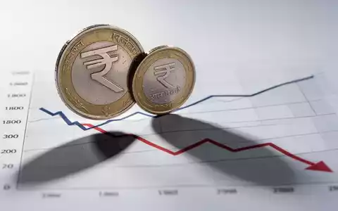 Eine indische Rupienmünze wirft einen langen Schatten auf ein Diagramm mit einem Abwärtstrend, das Dividenden trotz Verlusten symbolisiert. - Foto: über boerse-global.de