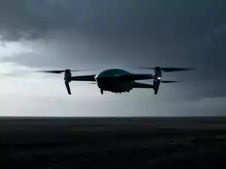 Eine moderne Drohne fliegt über eine weite Landschaft unter einem leicht bedrohlichen Himmel, die Silhouette betont ihre Technologie. - Foto: über boerse-global.de