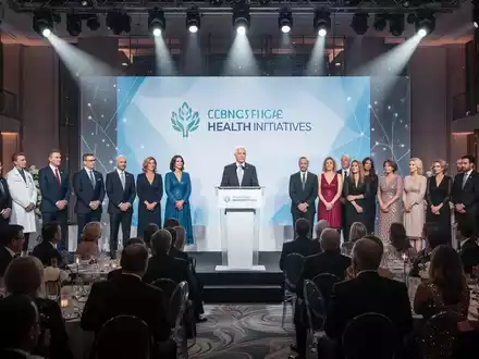 Eine festliche Gala-Veranstaltung mit prominenten Gästen und Politikern, die auf einer Bühne über Gesundheitsinitiativen sprechen. - Foto: über boerse-global.de