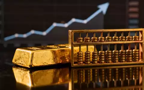 Ein glänzender Goldbarren neben einem traditionellen chinesischen Abakus, mit einem verschwommenen Finanzchart im Hintergrund. - Foto: über boerse-global.de