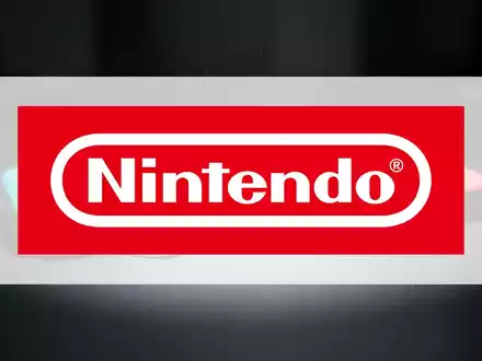 Eine Nintendo Switch Konsole liegt auf einer dunklen Oberfläche, dramatisch beleuchtet, um ein 52-Wochen-Tief zu symbolisieren. - Foto: über boerse-global.de