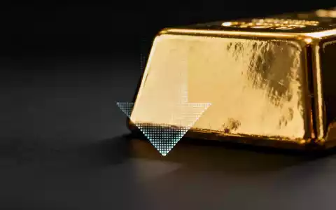 Ein glänzender Goldbarren, teilweise verdeckt von einem dezenten, digitalen Abwärtspfeil, vor dunklem Hintergrund. - Foto: über boerse-global.de