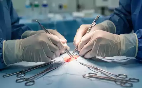 Nahaufnahme der Hände eines Chirurgen in sterilen Handschuhen, der eine präzise Operation in einem Operationssaal durchführt. - Foto: über boerse-global.de