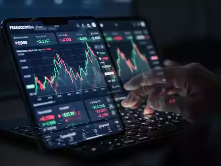 Ein Smartphone-Bildschirm zeigt eine betrügerische Online-Investmentplattform mit riskanten Diagrammen und Zahlen, während eine Hand tippt. - Foto: über boerse-global.de