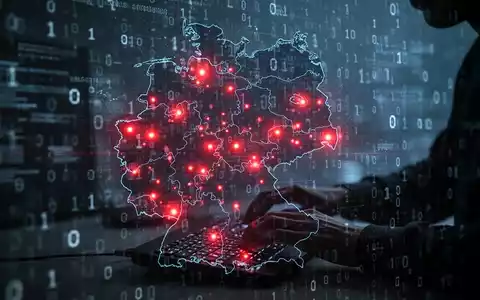 An abstract digital map of Germany showing red hotspots, overlaid with binary code and a shadowy figure typing, symbolizing cyberattacks. - Foto: über boerse-global.de