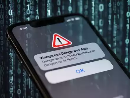 A smartphone screen shows a warning notification about a dangerous app, with a background of digital code. - Foto: über boerse-global.de