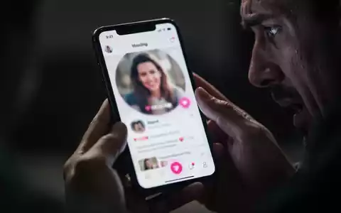 Nahaufnahme eines Smartphones mit einer Dating-App, das von besorgten Händen gehalten wird, im Hintergrund verschwommen. - Foto: über boerse-global.de