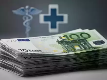 Ein Stapel Euro-Banknoten mit einem verschwommenen medizinischen Symbol im Hintergrund, das Finanzierung und Gesundheitswesen darstellt. - Foto: über boerse-global.de