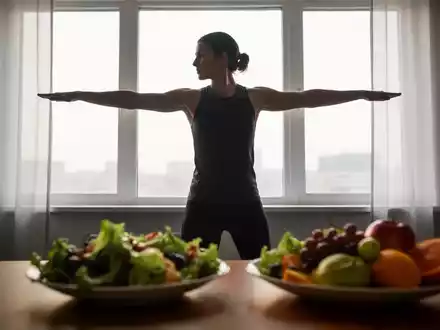 Eine Person macht Sportübungen vor einem Fenster, im Vordergrund ein gesunder Salat, der Ernährung und Bewegung symbolisiert. - Foto: über boerse-global.de