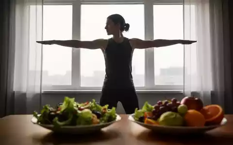 Eine Person macht Sportübungen vor einem Fenster, im Vordergrund ein gesunder Salat, der Ernährung und Bewegung symbolisiert. - Foto: über boerse-global.de