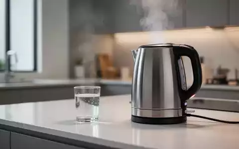 Ein moderner Wasserkocher steht auf einer minimalistischen Küchenarbeitsplatte, symbolisiert Energieeffizienz und Wassererhitzung im Haushalt. - Foto: über boerse-global.de