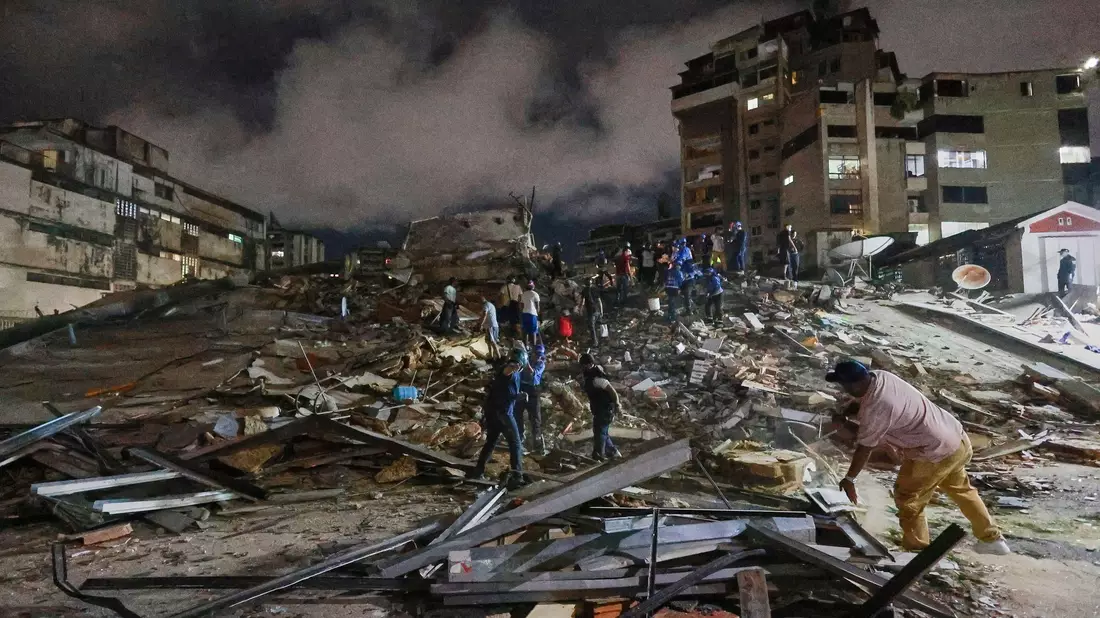 Rettungskräfte in Venezuela durchsuchen Trümmer. - Bild: Javier Campos/AP/dpa
