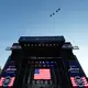 Die versammelte Menge sah in Formation fliegende Kampfjets am Himmel.  - Bild: Alex Brandon/AP/dpa