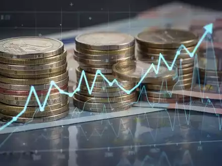 Ein Stapel Euro-Münzen und Banknoten, die ein Diagramm mit einem Abwärtstrend widerspiegeln, symbolisieren finanzielle Herausforderungen in der GKV. - Foto: über boerse-global.de