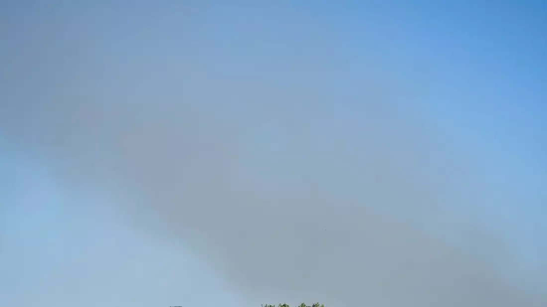 Eine Rauchsäule steigt unweit des Festivalgeländes in die Luft - Bild: Philip Dulian/dpa