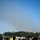 Eine Rauchsäule steigt unweit des Festivalgeländes in die Luft - Bild: Philip Dulian/dpa