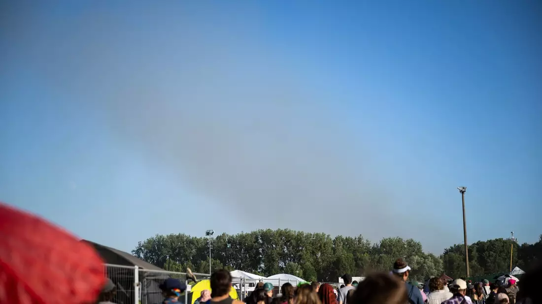 Eine Rauchsäule steigt unweit des Festivalgeländes in die Luft. - Bild: Philip Dulian/dpa