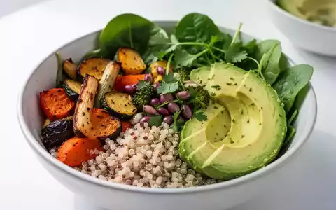 Eine Nahaufnahme einer bunten, gesunden veganen Buddha-Schale mit Quinoa, geröstetem Gemüse, Avocado und Blattgemüse. - Foto: über boerse-global.de
