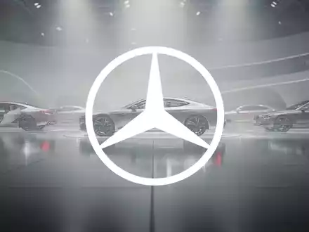 Abstrakte, atmosphärische Darstellung der Automobilindustrie mit weichen Lichtern und undefinierten Fahrzeugsilhouetten in einer modernen Umgebung. - Foto: über boerse-global.de