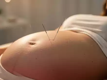 Eine Akupunkturnadel, die vorsichtig auf dem Bauch einer schwangeren Frau platziert ist, in einem ruhigen, warmen Licht. - Foto: über boerse-global.de