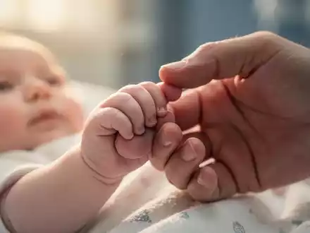 Eine kleine Babyhand greift sanft nach dem Finger eines Erwachsenen, symbolisiert Fürsorge und gesunde Ernährung. - Foto: über boerse-global.de