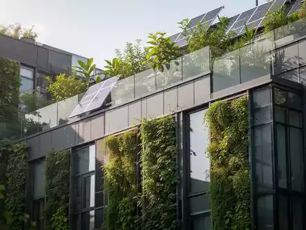 Nahaufnahme einer modernen, energieeffizienten Gebäudefassade mit vertikalen Gärten und Begrünung, die nachhaltige Immobilieninvestitionen symbolisiert. - Foto: über boerse-global.de