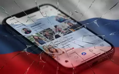 Zerbrochener Smartphone-Bildschirm mit verschwommener Social-Media-App, dezent überlagert von einer beschädigten russischen Flagge. - Foto: über boerse-global.de