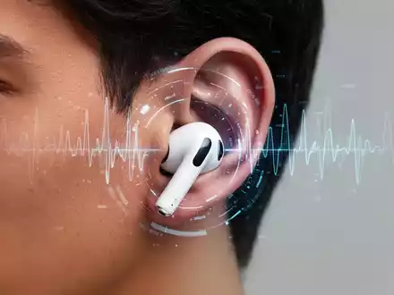 Nahaufnahme eines Ohrs mit weißem Apple AirPods Pro 3, dezente digitale Gesundheitsgrafiken. - Foto: über boerse-global.de