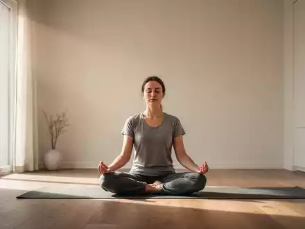 Eine Person sitzt in einem minimalistischen Raum in meditativer Pose, umgeben von sanftem Licht, das Ruhe und Besinnung symbolisiert. - Foto: über boerse-global.de