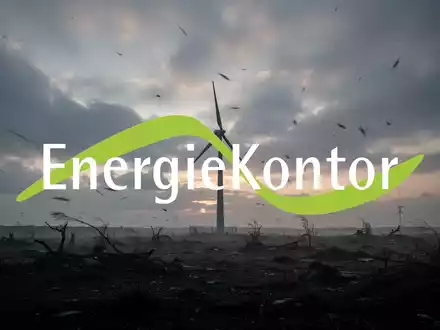 Eine einsame Windkraftanlage in einer windgepeitschten Landschaft bei Sonnenuntergang unter einem bewölkten Himmel, die Rückgang im Energiesektor darstellt. - Foto: über boerse-global.de