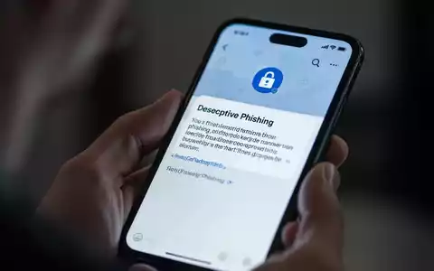 Nahaufnahme eines Smartphones, das eine Phishing-Nachricht anzeigt, während eine Hand das Gerät hält. Fokus auf digitale Bedrohungen. - Foto: über boerse-global.de