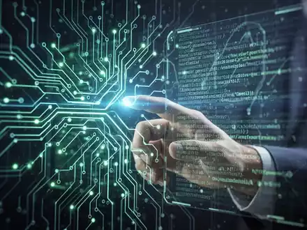 Stilisierte Darstellung einer menschlichen Hand, die mit einer leuchtenden, futuristischen holografischen Schnittstelle interagiert, die KI-Training und Unternehmensberatung symbolisiert. - Foto: über boerse-global.de