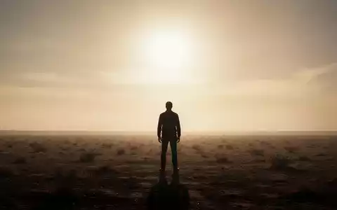 Eine einzelne, stilisierte Person in einer weiten, trockenen Landschaft unter einem sengenden, diesigen Himmel, der Hitze und Isolation symbolisiert. - Foto: über boerse-global.de