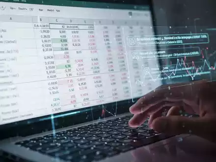 Digitales Tabellenblatt auf einem Bildschirm mit Daten und Formeln, KI-Vorschlägen und einer unscharfen Hand über einer Tastatur. - Foto: über boerse-global.de