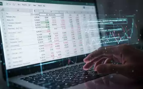 Digitales Tabellenblatt auf einem Bildschirm mit Daten und Formeln, KI-Vorschlägen und einer unscharfen Hand über einer Tastatur. - Foto: über boerse-global.de