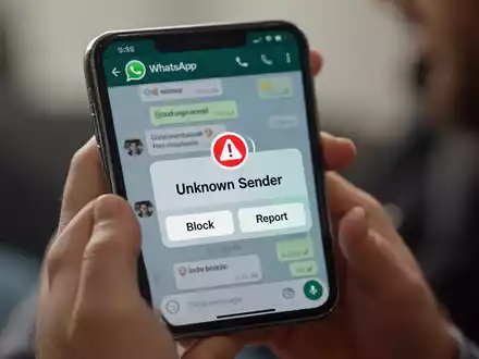 Ein Smartphone zeigt eine WhatsApp-Sicherheitswarnung vor unscharfem Hintergrund mit Händen, die das Gerät halten, und veranschaulicht neue Betrugsschutzfunktionen. - Foto: über boerse-global.de