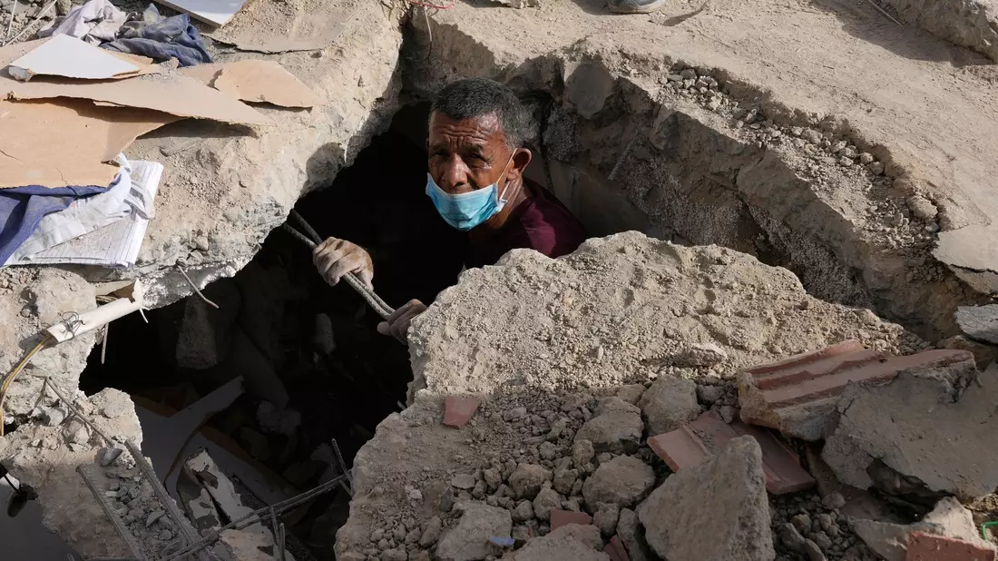 Helfer suchen teils mit bloßen Händen nach Verschütteten. - Bild: Ariana Cubillos/AP/dpa