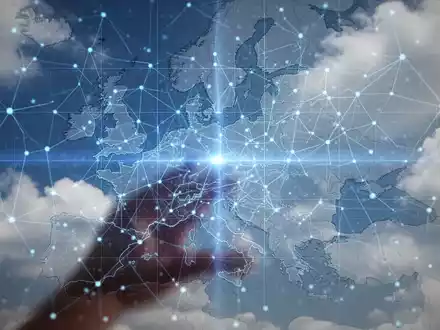 Leuchtend blaues digitales Netzwerkgitter über einer dezenten Europakarte mit abstrakten Wolkenformationen im Hintergrund. - Foto: über boerse-global.de