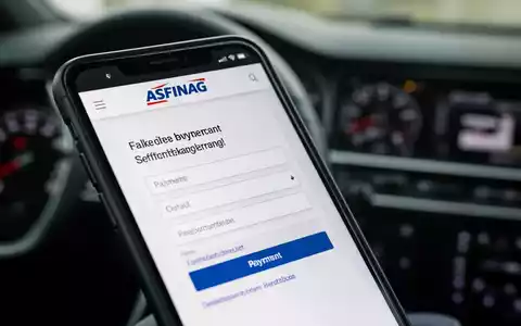 Nahaufnahme eines Smartphone-Bildschirms mit einer gefälschten ASFINAG-Website und einem Zahlungsformular auf einem Armaturenbrett. - Foto: über boerse-global.de