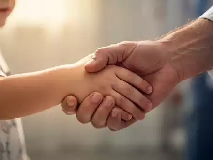 Eine Kinderhand hält sanft eine Erwachsenenhand, symbolisierend Fürsorge und Hoffnung bei einer neurologischen Erkrankung. - Foto: über boerse-global.de