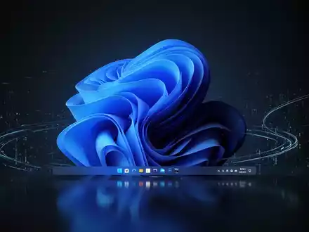 Leuchtend blaue Windows 11 Taskleiste auf dunklem, spiegelndem Desktop mit subtilen digitalen Lichtspuren. - Foto: über boerse-global.de