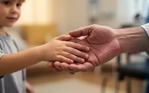 Eine Kinderhand berührt sanft eine Erwachsenenhand, die beide leichte Anzeichen von Gelenkbeschwerden aufweisen. - Foto: über boerse-global.de
