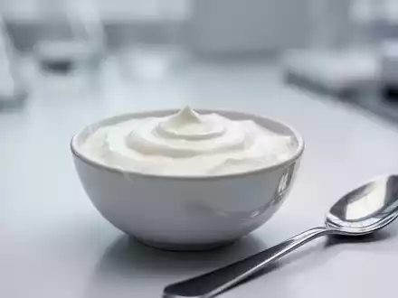 Nahaufnahme einer Schale mit Naturjoghurt und einem Löffel daneben. Der Hintergrund ist unscharf, was eine saubere Umgebung andeutet. - Foto: über boerse-global.de