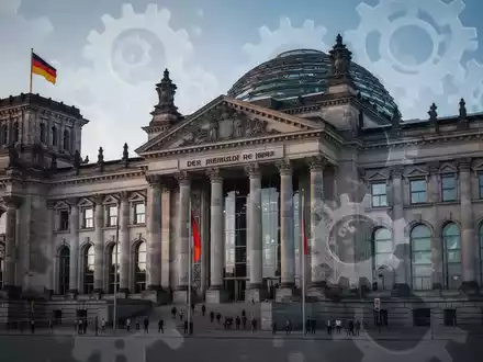 Das Reichstagsgebäude in Berlin, symbolisch für politische Debatten und die Rentenreform, mit angedeuteten Zahnrädern. - Foto: über boerse-global.de