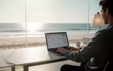 Eine Person arbeitet an einem Laptop an einem Schreibtisch mit Blick auf einen sonnigen Strand und das Meer. - Foto: über boerse-global.de
